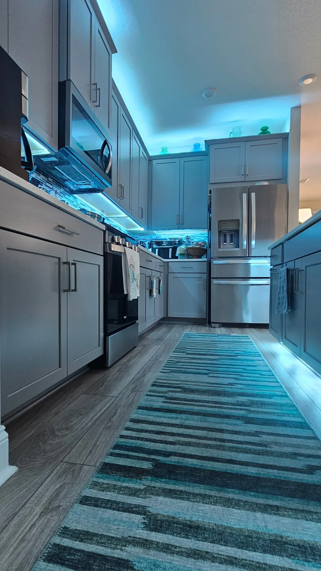 A hallway runner lit teal after dark