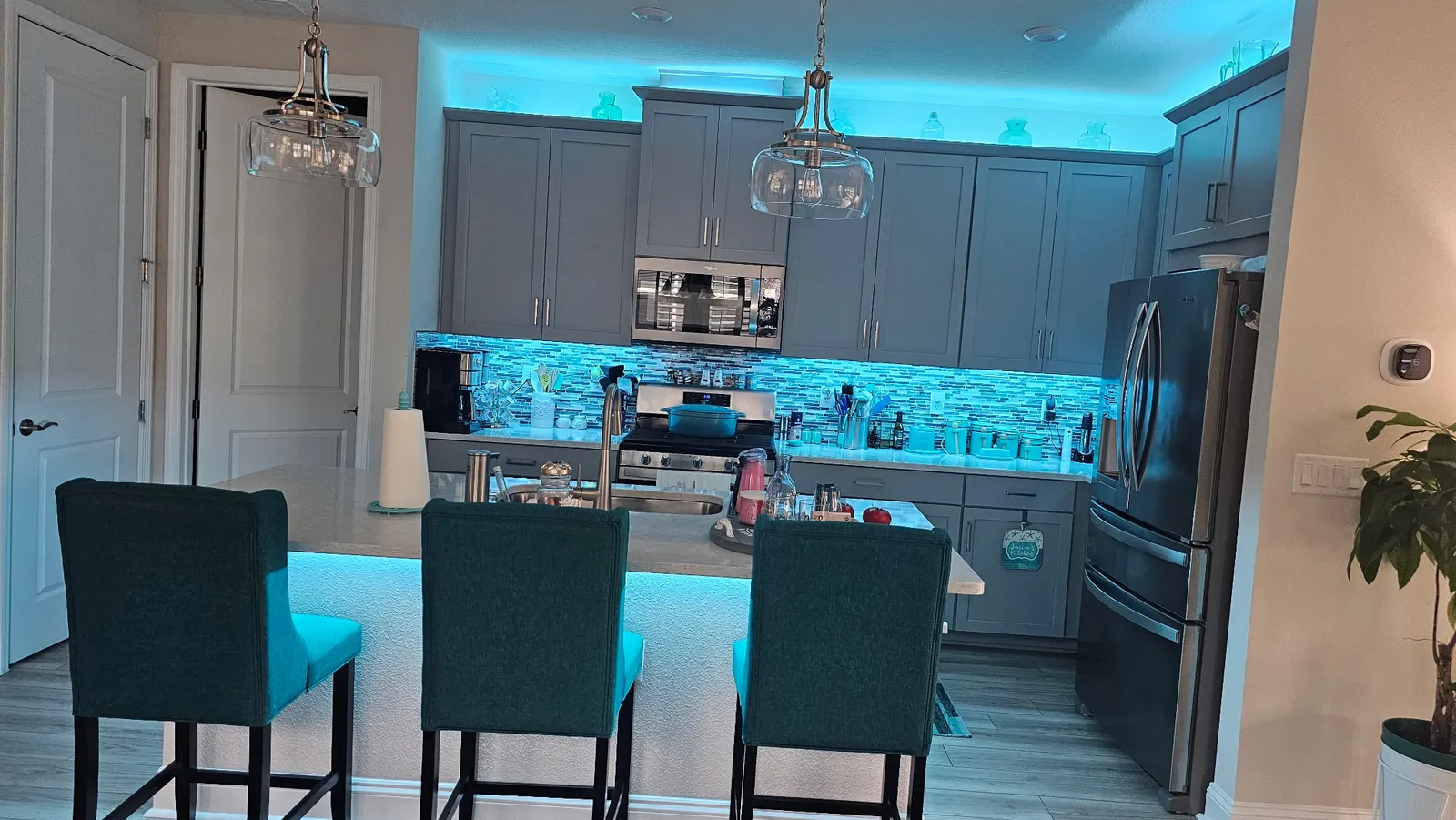 The teal kitchen and bar, seating lit