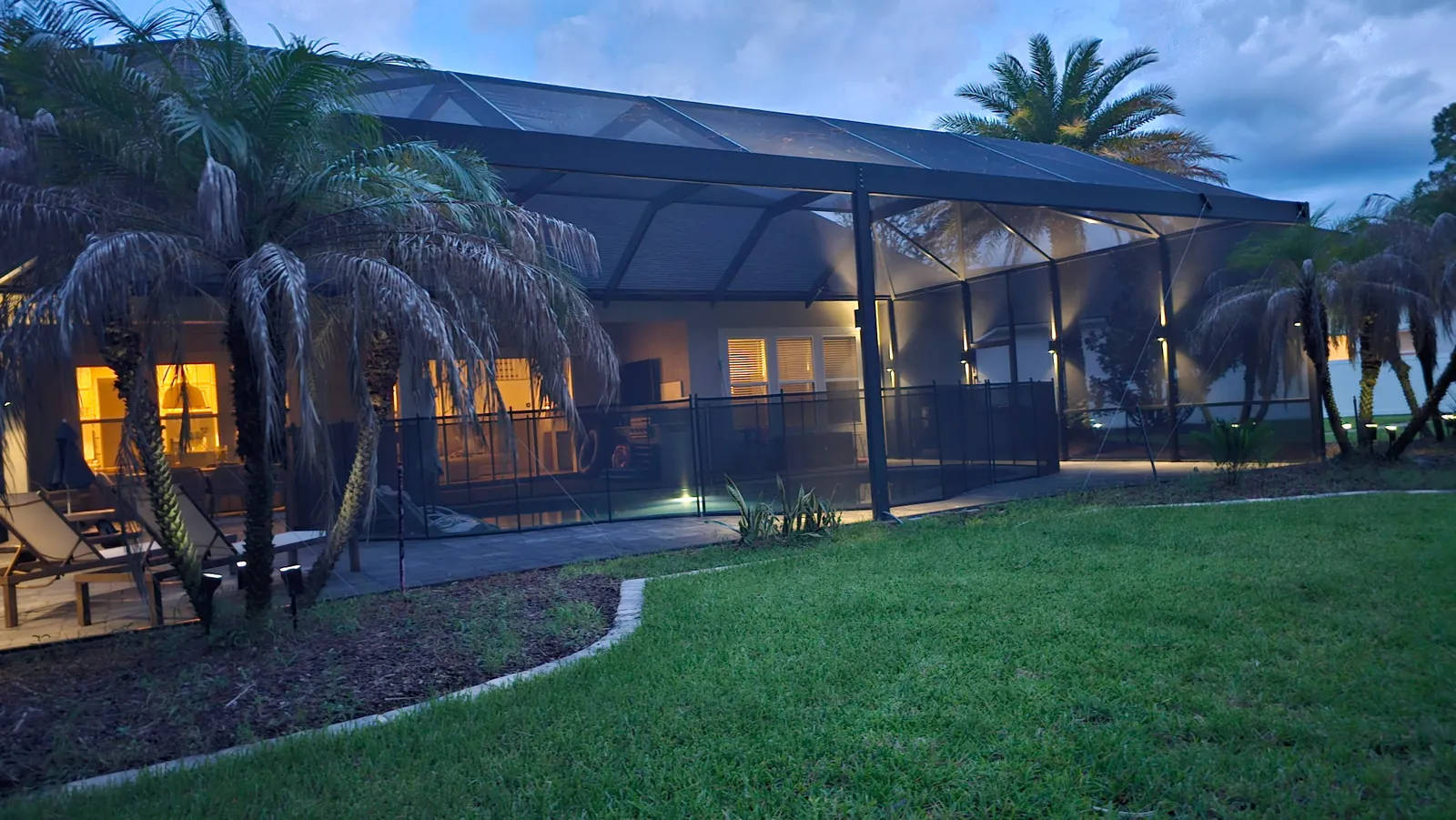The house elevation at dusk, lit from the landscape