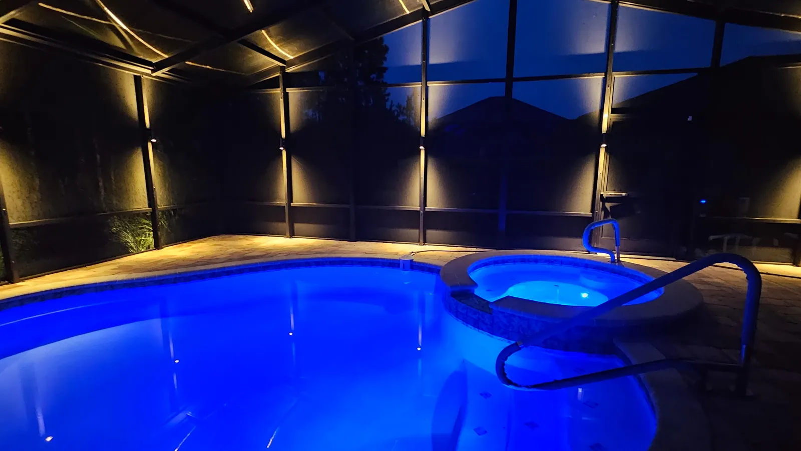 Pool and spa run blue under the warm sconces