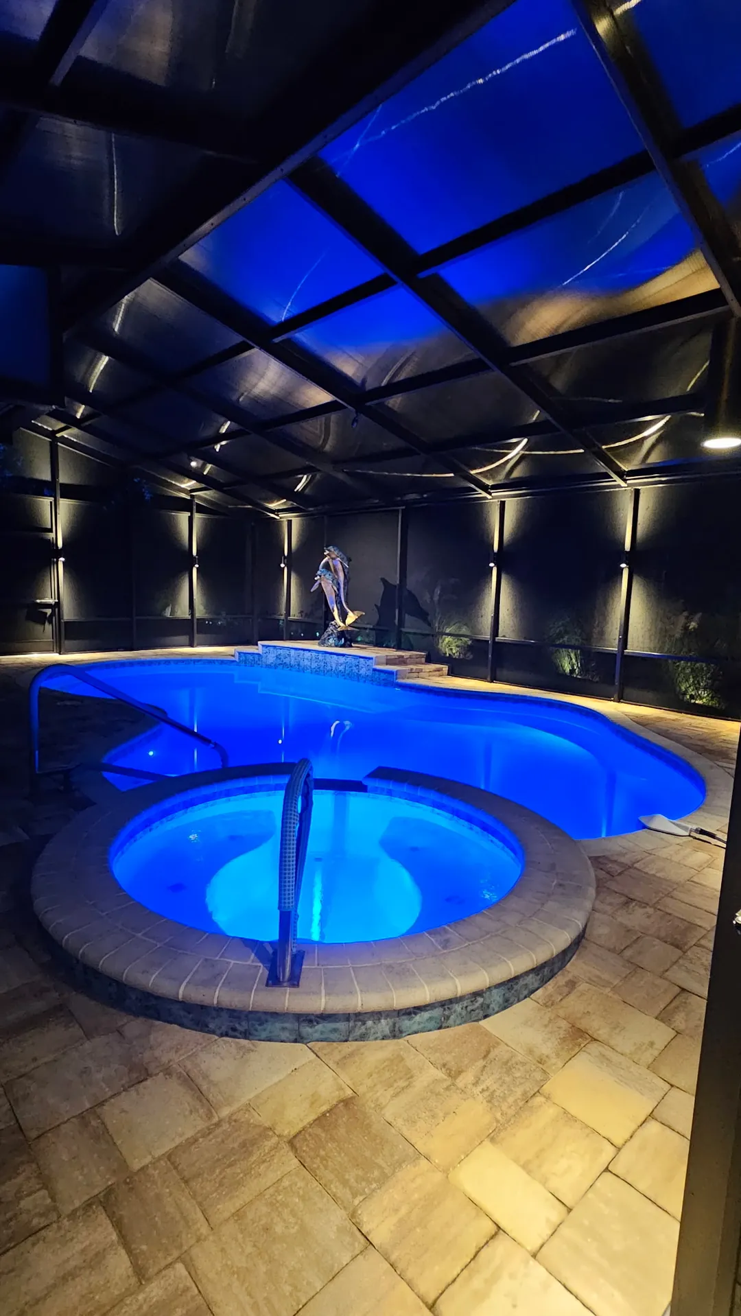 The spa lit blue, deck lighting around the curb